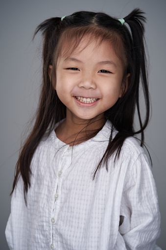 Portrait of positive cheerful girl cutely smiling, girl with long blonde hair in white t-shirt