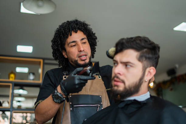 istock male stylist performs haircut to a client 1455998409