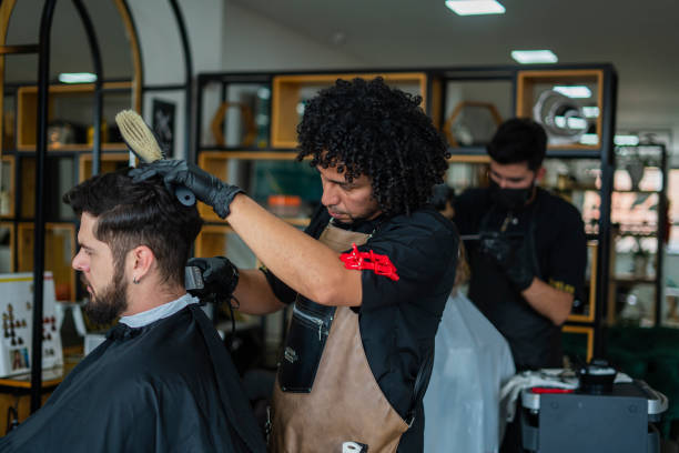 istock male stylist performs haircut to a client 1455998470