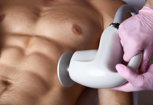 Man receiving fat reductive skin lifting body treatment on modern equipment at cosmetology clinic stock photo