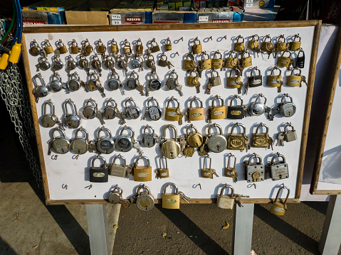 Trichy, Tamil Nadu, India - February 2020: Small pad locks on display for sale at a roadside store in a market in the city.