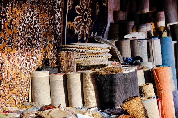 istock Stack of multicolored quality rugs at carpet shop, Carpets variety selection rolled up rugs shop store. 1456002468