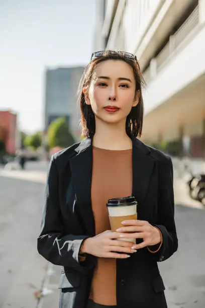 Photo of Successful female manager standing on the city street.