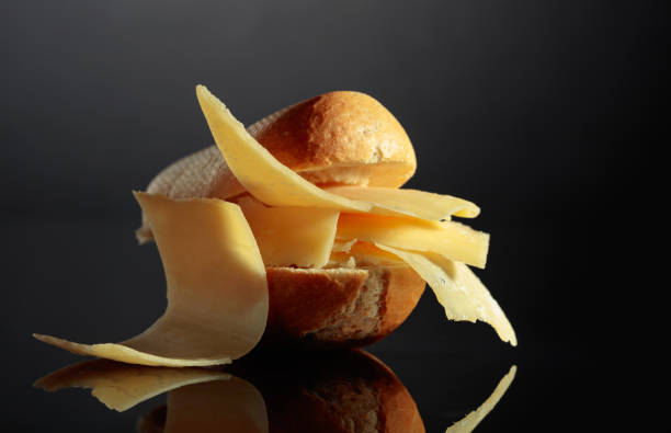 Sandwich with Parmesan cheese on a black reflective background.