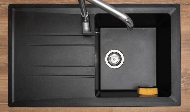 istock Organizer holder for a kitchen sponge in a black granite sink. Storage and organization of space 1456006552
