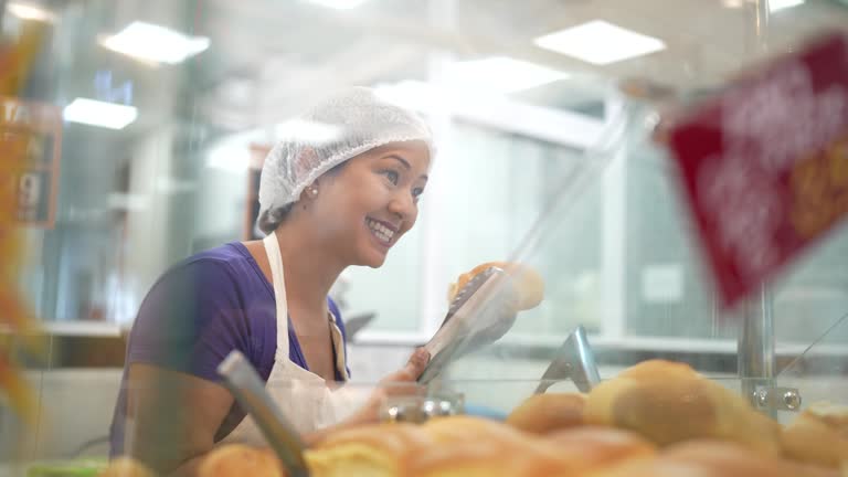 Employee getting bread to a customer in a bakery