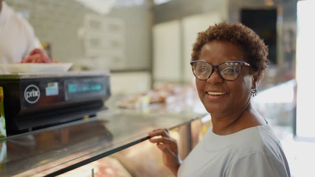 Portrait of a senior woman buying meat in a butcher's shop