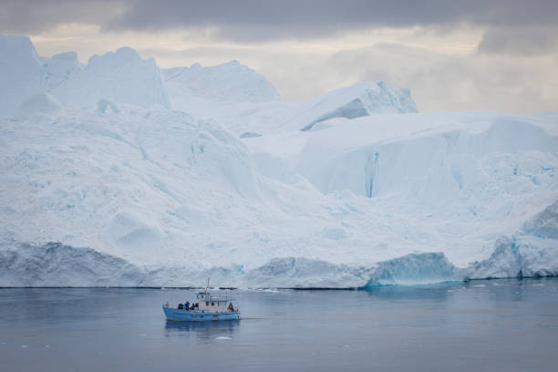 istock small boats sailing near big icebergs 1456015921