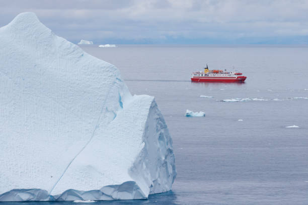 istock small boats sailing near big icebergs 1456015925
