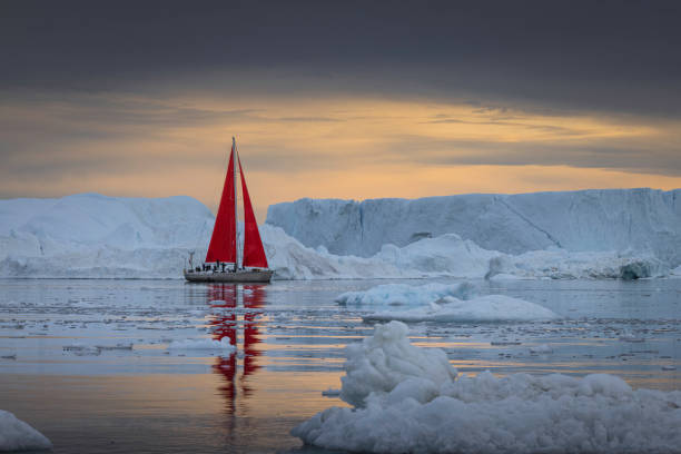 istock small boats sailing near big icebergs 1456015945