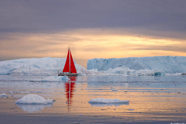 istock small boats sailing near big icebergs 1456015948