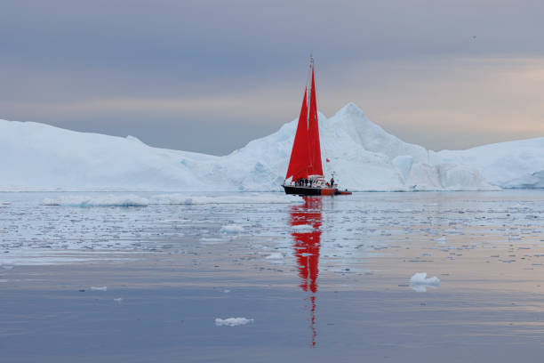 istock small boats sailing near big icebergs 1456015951