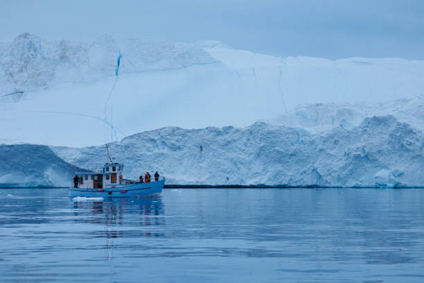 istock small boats sailing near big icebergs 1456015986