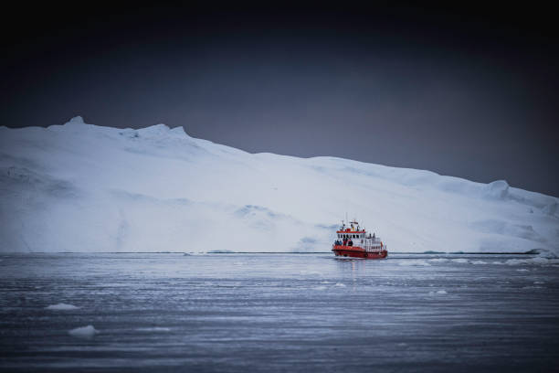 istock small boats sailing near big icebergs 1456016018