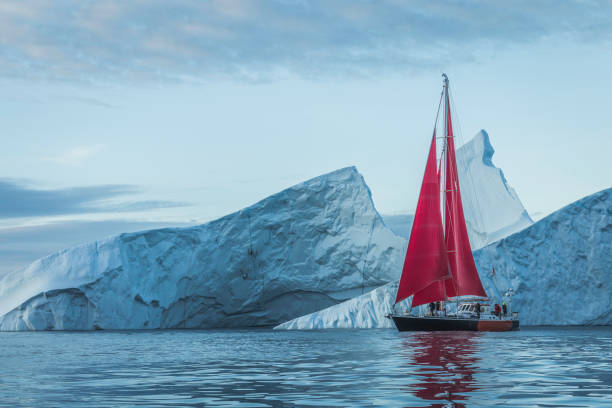 istock small boats sailing near big icebergs 1456016076