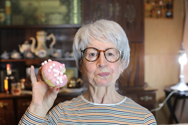 istock Senior woman chewing a doughnut 1456016665