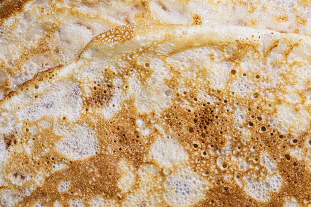 istock Pancake surface texture and pattern. Close-up of thin hot pancakes in a plate. Traditional rustic food. Graphic resource. 1456018503
