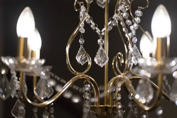 A close-up shot of a vintage-style chandelier with decorative diamonds