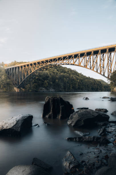 istock Bridge over the river in an autumn forest during sunset 1456018811