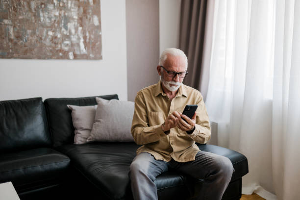 istock Serious Elderly man grandfather using smart phone, searching web, loading feed, social media. Communication with children, grandchildren on lockdown 1456021158