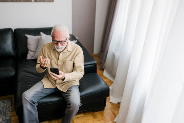 istock Smiling Elderly man grandfather using smart phone, searching web, loading feed, social media. Communication with children, grandchildren on lockdown 1456021203