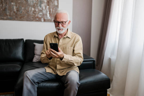 istock Smiling Elderly man grandfather using smart phone, searching web, loading feed, social media. Communication with children, grandchildren on lockdown 1456021226