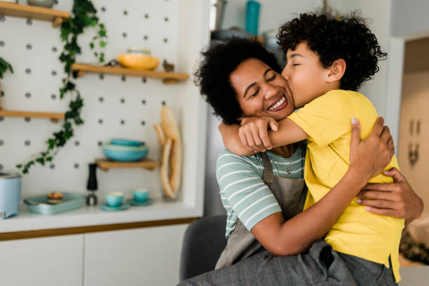 lächelnde familie in einer umarmung, mutter und kleiner sohn., mutter umarmt ihr männliches kind - child eating healthy eating healthy lifestyle stock-fotos und bilder