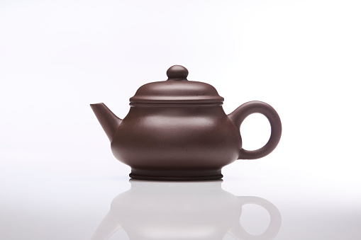 Chinese deep brown teapot isolated on white background; studio shot.