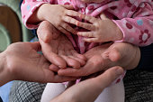 The hands of a multi-generational family are stacked together.