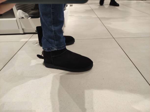 istock Man trying on black winter boots in a store 1456023044