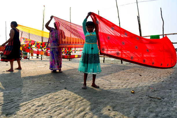 Hindu women dry their clothes after taking a Holy bath during the Makar Sankranti festival. Gangasagar is one of the religious spot for the Hindu Pilgrims situated at Bay of Bengal where every year millions of devotees come to take a Holy bath during Makar Sankranti (Transition of Sun) as per Hindu calendar and offer prayers to Kapil Muni Temple. The date for this Festival usually fall between 13 to 15 January of ever year.