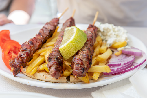 Traditional Greek food served in tavern, made from Kebab Beef Souvlaki, french fries, salad and pita bread