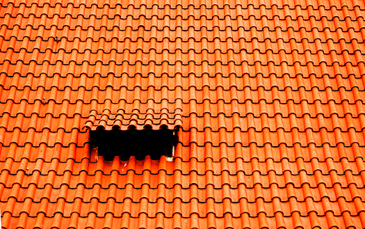 roofer work of a roof area window: velux style roof light window in red tiles