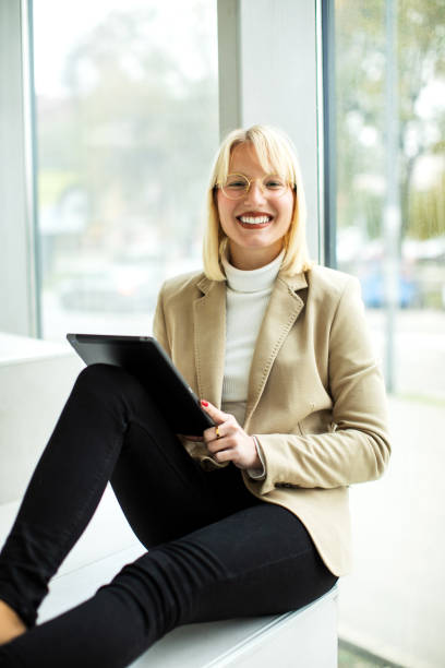 istock Young blond female businesswoman  working on a digital tablet inside modern building 1456025122