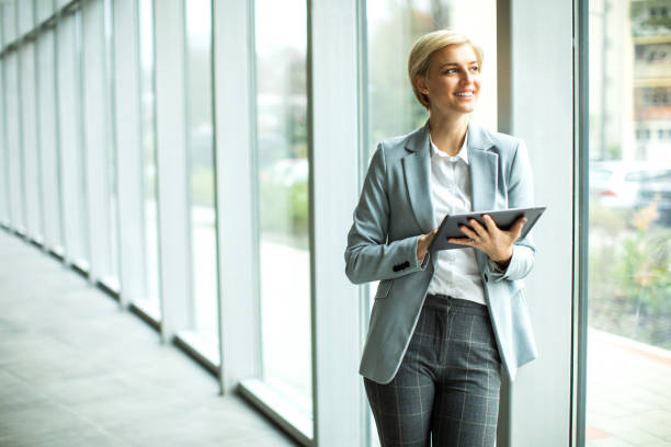 istock Young blond female businesswoman  working on a digital tablet inside modern building 1456027594