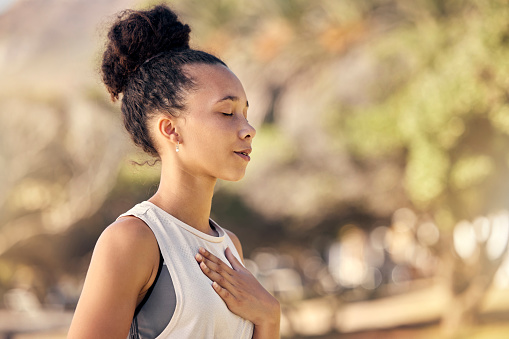 Mujer negra, respiración y mano en el pecho, para la meditación y el bienestar siendo pacífico para relajarse. Bokeh, mujer afroamericana y dama al aire libre, en la naturaleza y en calma para respirar, hacer ejercicio y salud. photo