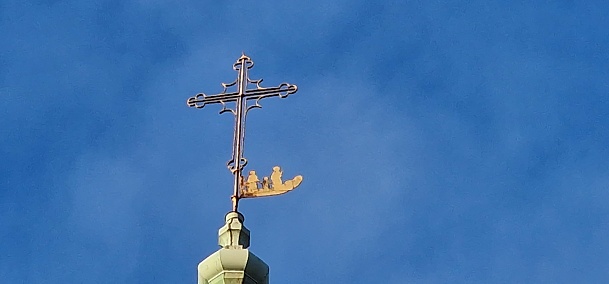 a cross over a church with human figures