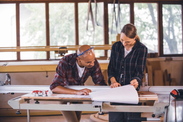 istock Couple of young carpenter working together 1456033751