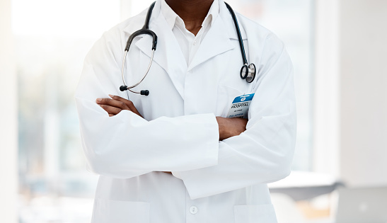 Hospital, medical and body of confident doctor ready for medicine research, cardiology work or healthcare support. Professional job, career worker or black man with crossed arms, pride and confidence