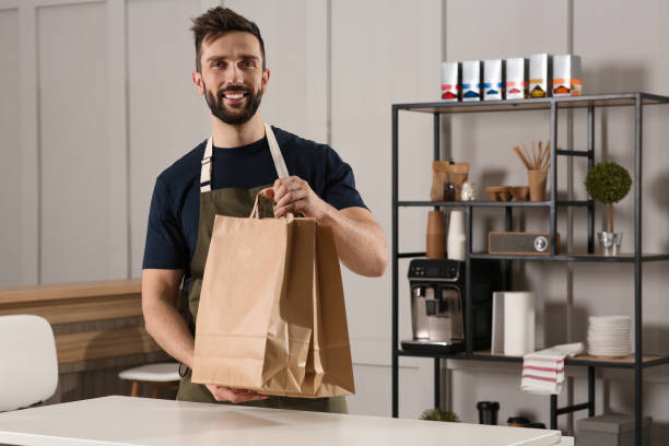 istock Worker with paper bags at counter in cafe, space for text 1456038194