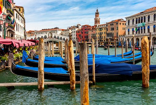 Venice, Italy - October 2022: Gondolas on Grand canal with Rialto bridge at background