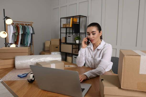 istock Seller talking on phone while working with laptop in office. Online store 1456038246