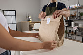 arbeiter-gibt-papiert%C3%BCte-an-kunden-