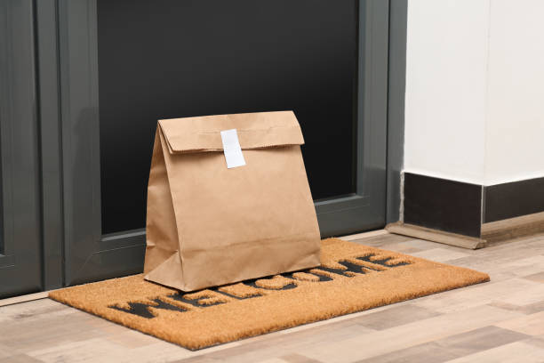 paper bag on door mat near entrance indoors - paper bag bag packed lunch paper imagens e fotografias de stock