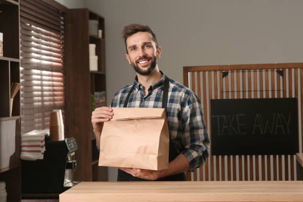 istock Worker with paper bag at counter in cafe 1456038352