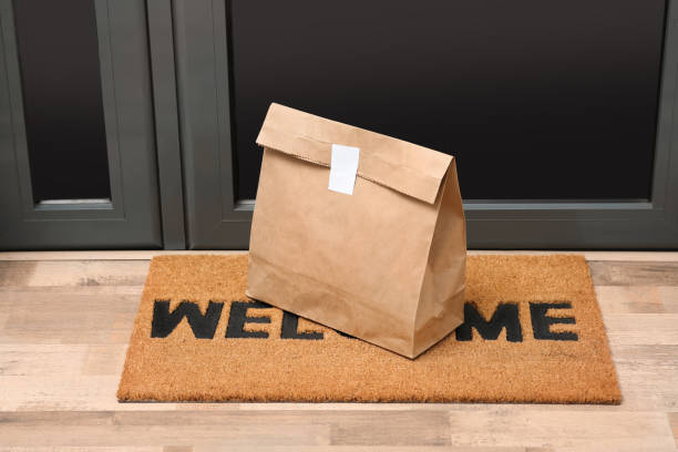 paper bag on door mat near entrance indoors - paper bag bag packed lunch paper imagens e fotografias de stock