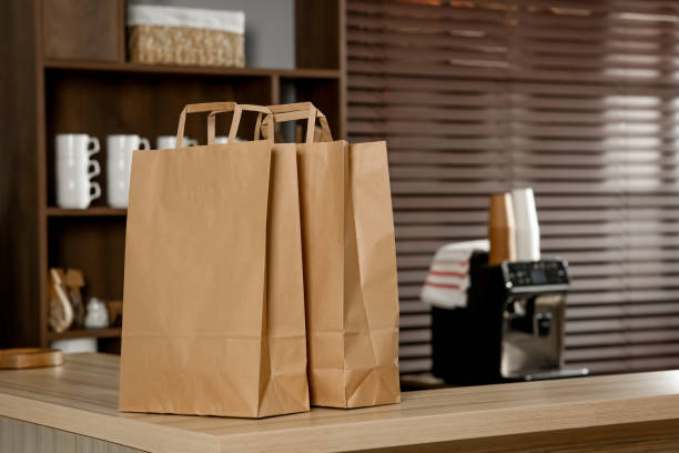 paper bag on wooden counter in cafe, space for text - paper bag bag packed lunch paper imagens e fotografias de stock