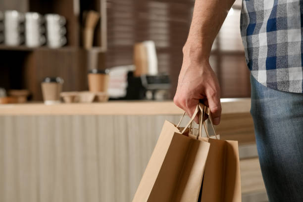 man with paper bags in cafe, closeup. space for text - paper bag bag packed lunch paper imagens e fotografias de stock