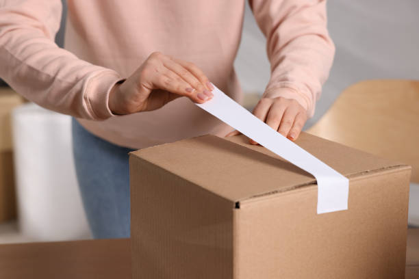 istock Seller taping parcel at workplace, closeup view 1456039351