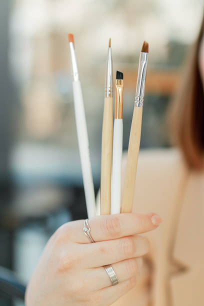 istock Eyebrow brushes in a hand of an artist 1456039716